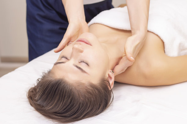 按摩、拉伸颈部肌肉。美丽的女孩在水疗沙龙接受按摩。照片色调。按摩养生理念。风湿、关节图片下载