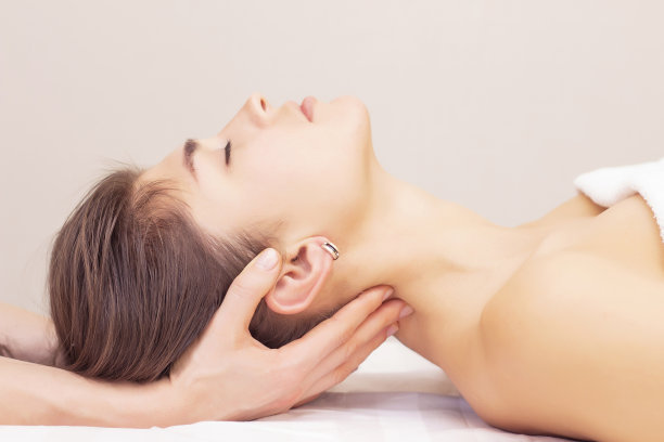 按摩、拉伸颈部肌肉。美丽的女孩在水疗沙龙接受按摩。照片色调。按摩养生理念。风湿、关节图片下载