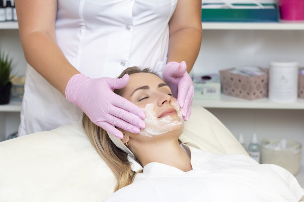 美容。可爱的年轻女子闭着眼睛在美容院接受面部清洁手术的特写照片。图片下载