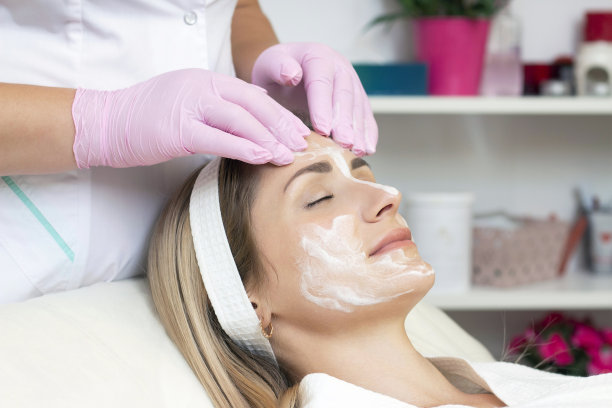 美容。可爱的年轻女子闭着眼睛在美容院接受面部清洁手术的特写照片。图片下载