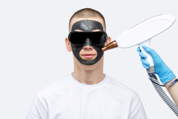 美容师在美容院给帅哥做脱碳手术。硬件男性美容。图片下载