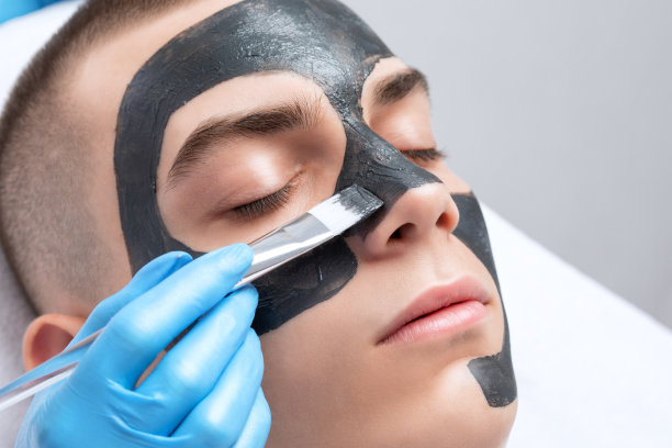 美容师在美容院给帅哥做脱碳手术。硬件男性美容。图片下载