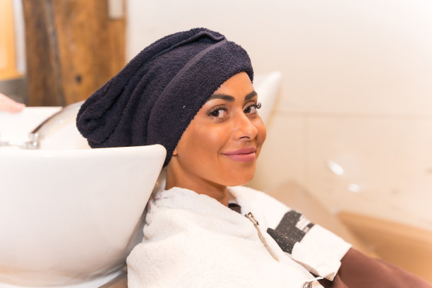 一个深色头发的女人坐在美容院里吹头发图片下载