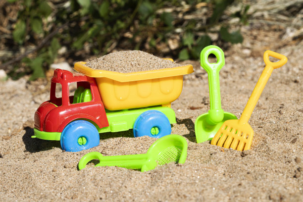 五彩缤纷的儿童沙滩玩具在沙的背景图片下载