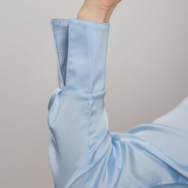 摄影工作室的年轻女性模特穿着浅蓝色丝绸缎包裹衬衫图片下载