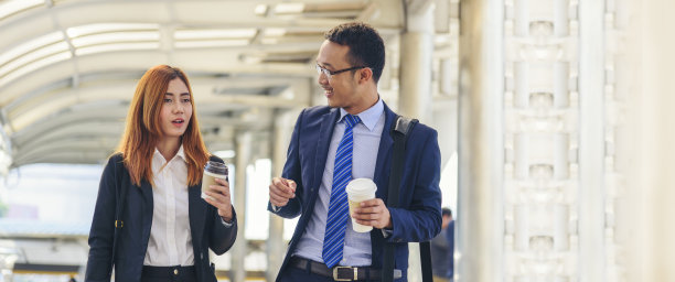 旗帜商人在办公城外用智能手机喝咖啡的女商人。全景牵手带走咖啡杯，智能手机一起聊天商业伙伴copyspace图片下载