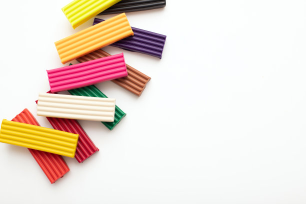 彩色橡皮泥造型粘土片或粘在孤立的白色背景。俯视图，特写，边框与拷贝空间。图片下载