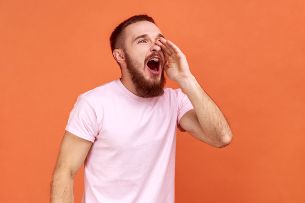 男人大声喊叫，手放在嘴边，尖叫着宣布他的意见。图片下载