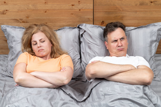 两个人躺在床上，一男一女躺着互相不满。关系的概念图片下载