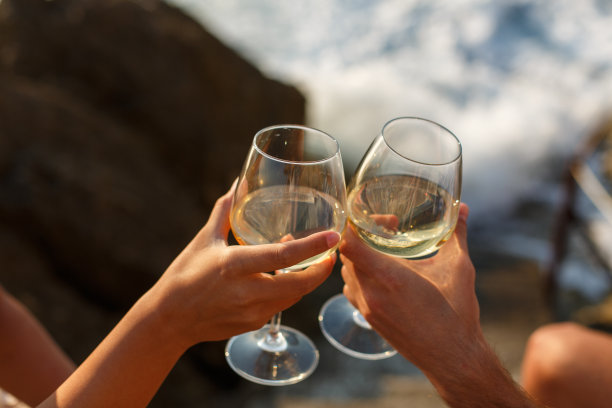 难以辨认的夫妇与白葡萄酒欢呼的特写镜头图片下载