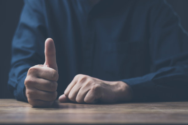 男人的手显示拇指它传达优秀，非常好，喜欢，或用于扫描到各种系统。图片下载