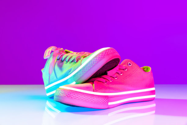 时尚运动鞋的形象，运动鞋孤立的彩色霓虹灯背景。都市都市时尚、健身、运动、训练理念。图片下载