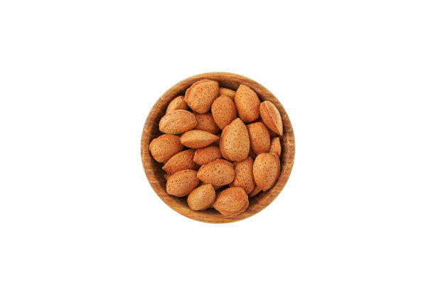 干杏仁在一个壳在木盘子上俯视图。白色背景，复制空间。设计元素,模板图片下载