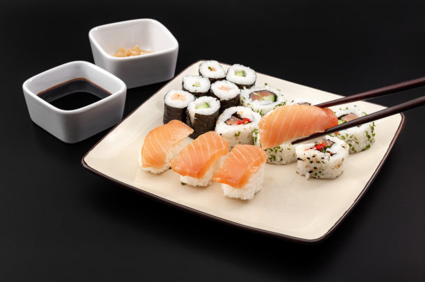 生鱼片，健康的食物和正宗的日本料理概念，照片上的寿司混合拼盘，各种卷孤立在黑色背景上，剪切路径切割图片下载