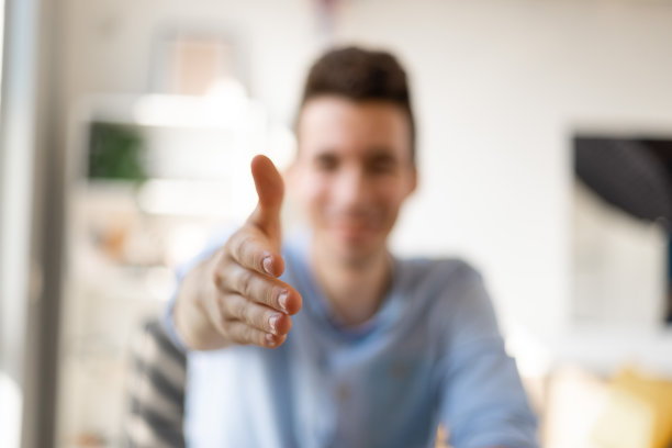 头像微笑的商人在镜头前伸出手握手，友好的人力资源经理在面试中问候候选人，提供交易。有选择性的重点图片下载