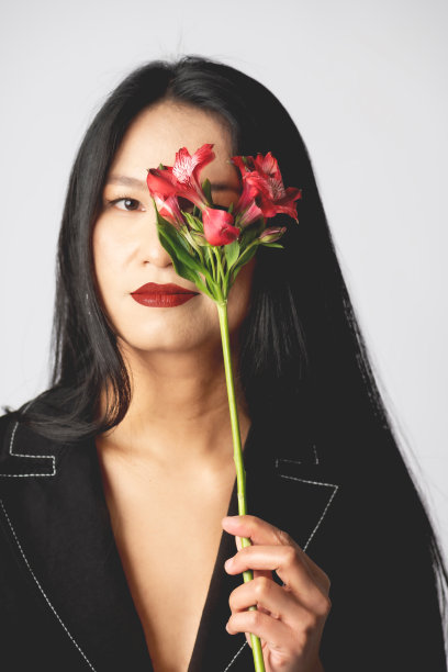 亚洲女性肖像用花盖住她的一只眼睛图片下载