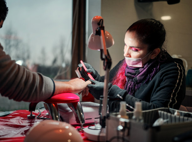 女性美甲师为拉丁裔男性做美甲，修剪指甲图片下载