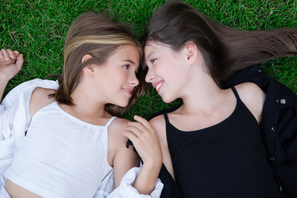 有个妹妹真是幸福又幸运。两个穿着黑白衣服的女孩在户外。好的和坏的。听话的和有害的。异卵双胞胎少女姐妹。图片下载