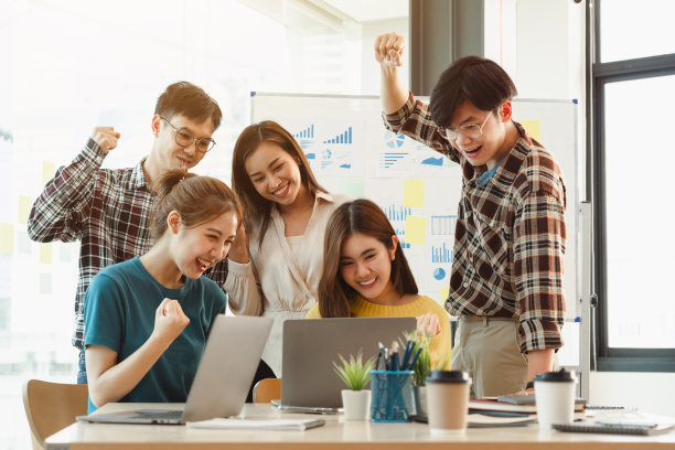 是的!快乐亚洲创业跨国公司年轻的业务经理成功完成了艰苦的项目，感到快乐，胜利，胜利。图片下载