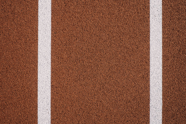 五彩缤纷的运动场背景。俯视红色场地，室外有白色线条的橡胶地面图片下载