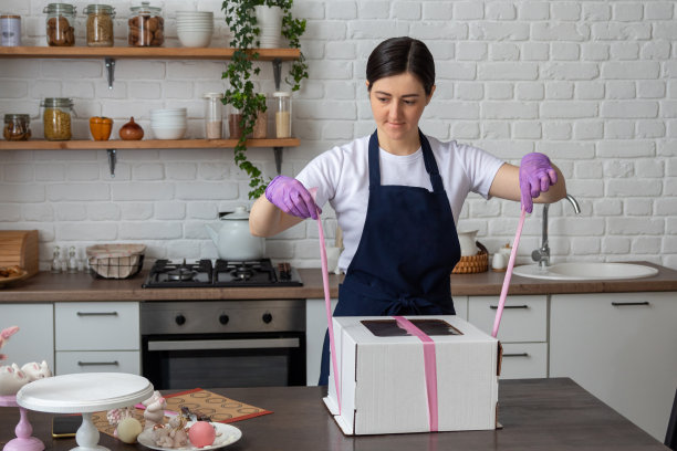 糕点师在打包送饼前用手握着彩带。有选择性的重点。关于糖果商、食物、爱好的照片。图片下载