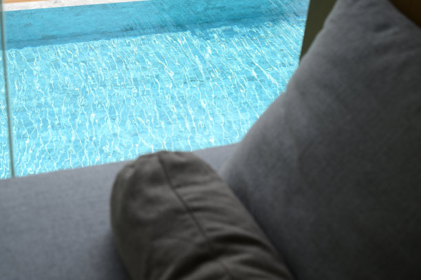 灰色枕头放在床上，泳池景图片下载