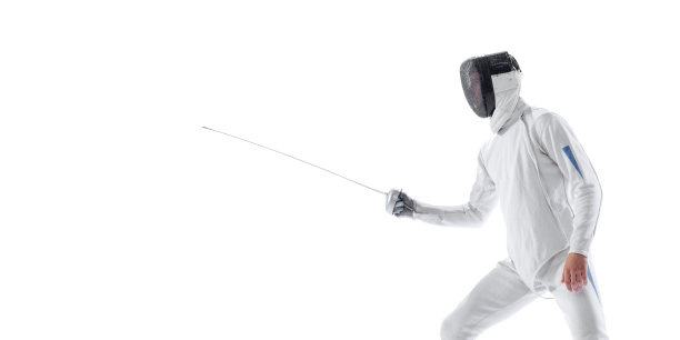 年轻男子动态肖像，击剑手握剑在击剑服训练孤立在白色的工作室背景。运动、能源、技能图片下载