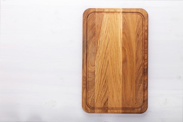 白色木桌上的长方形砧板。准备食物的工具和厨房用具。图片下载