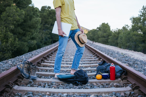 创业旅行者和数字游牧民在废弃的铁轨上扎营。概念数字工作和旅行。图片下载