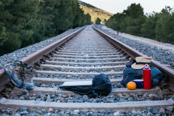 游牧数字的行李和电脑设备在火车轨道上。一边旅行一边在线工作的概念图片下载