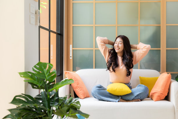 年轻微笑的女性在工作和会议后在家里放松。生活自由，快乐，在豪华客厅喝咖啡，在假期，假期和夏日。生活方式的概念图片下载