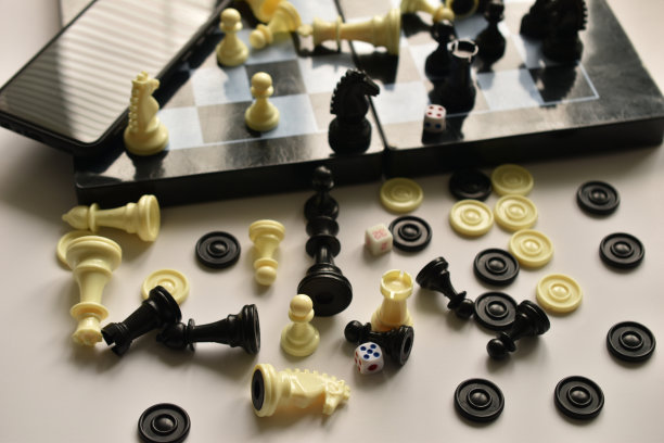 棋子随意地放在桌子和棋盘上。图片下载