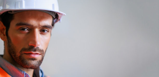 肖像专业机械工程西班牙裔男性在白色安全安全帽头盔和看镜头在金属工厂。专业工业仓库图片下载