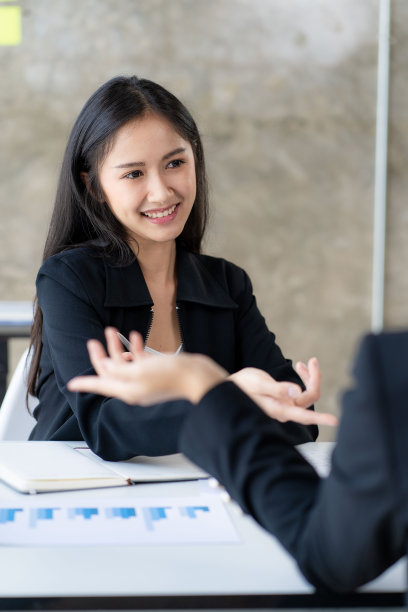 两个年轻的亚洲商人在办公室讨论投资营销，并介绍新的创业项目想法。分析、计划并绘制财务统计图。图片下载