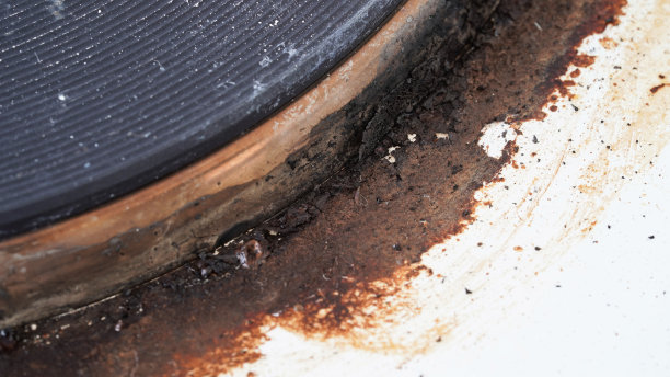 一个装着剩饭的脏炉子的特写。脏的煤气炉上有油渍、旧油渍、油炸渍和油渍飞溅。宏观照片。纹理图片下载