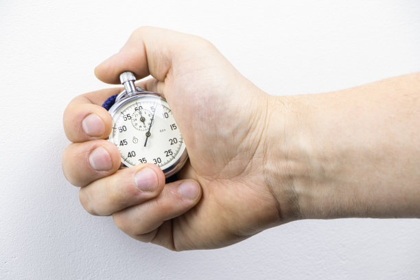 模拟秒表特写。手握秒表的男人。用秒表计时。时间测量。时间管理的概念。测量时间的工具表盘秒表箭头图片下载
