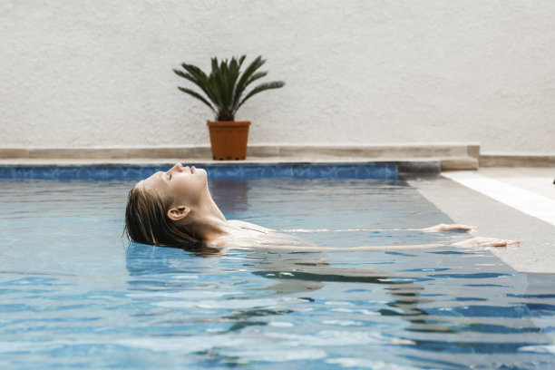 游泳池里的年轻女子。图片下载