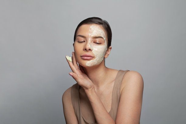 年轻迷人的女人放松水疗沙龙与化妆面具在她的脸图片下载