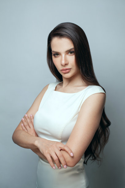 成功的华丽的深色模特女人与长头发和化妆在灰色的背景图片下载