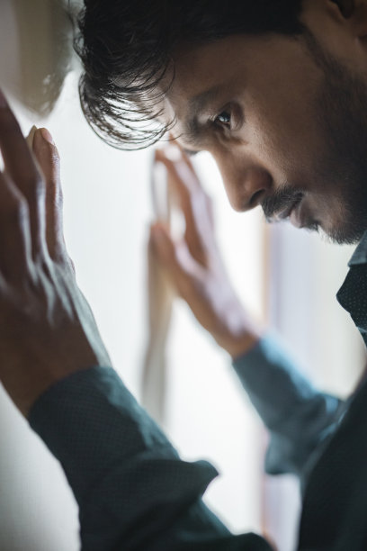 年轻人用头撞墙来忏悔。图片下载