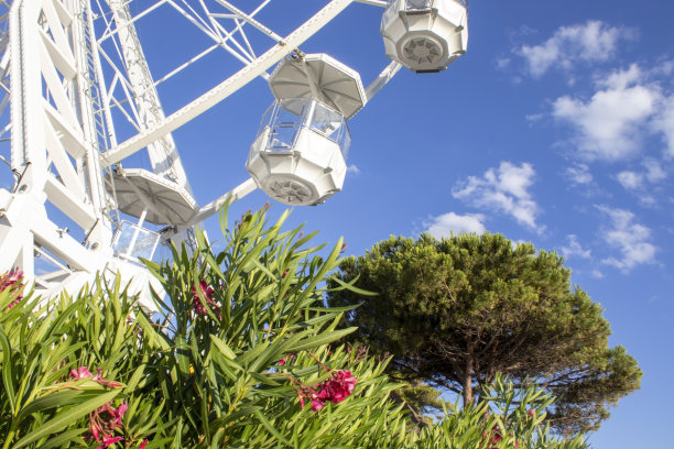 美丽的白色摩天轮在意大利卡拉布里亚清澈的蓝天下特写。摩天轮在蓝色多云的天空。图片下载