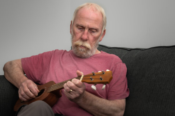 中年男子以弹尤克里里琴为爱好图片下载