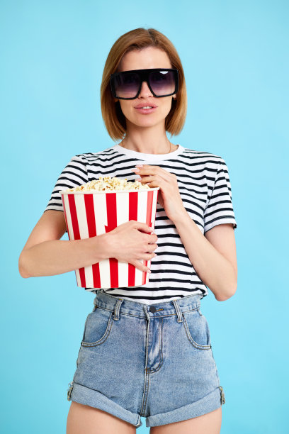 女人拿着一桶爆米花看电影图片下载