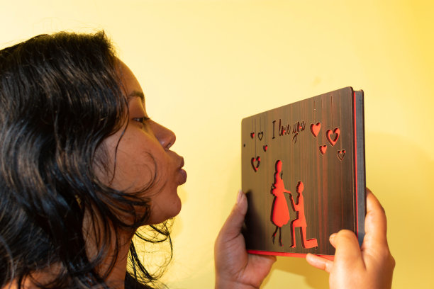 美丽快乐的印度女子与情人节礼盒。微笑的女人惊讶地拥抱了情人节礼物。图片下载