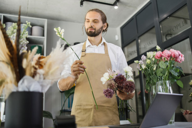 花店老板拿着不同的花束，看着相机图片下载
