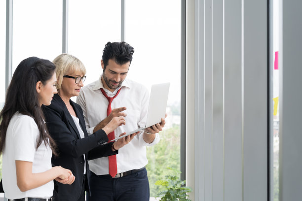 商人在笔记本电脑上讨论他的工作。一群公司不同的同事在办公室的笔记本电脑上进行头脑风暴和规划业务战略图片下载