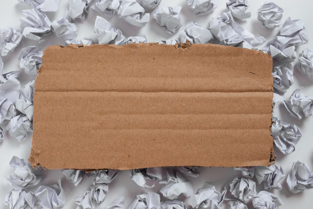 在硬纸板下面放有重要信息的包装纸。皱巴巴的笔记安排在纸板下面与关键的想法。上面有关键数据的皱巴巴的备忘录。图片下载