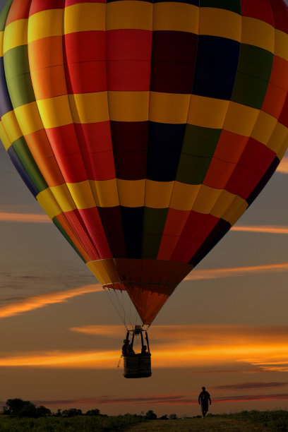 热气球在日落时低空漂浮图片下载