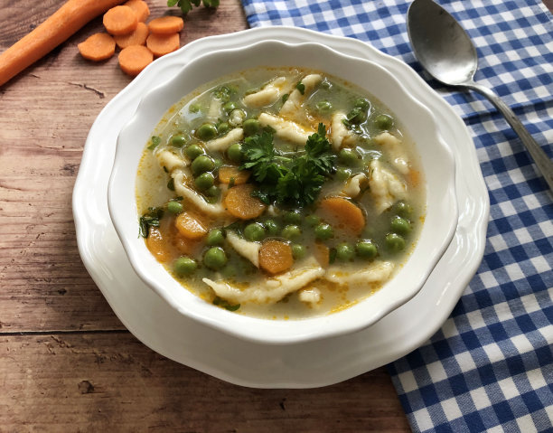 色彩鲜艳，新鲜的素食豌豆汤，胡萝卜，欧芹和匈牙利饺子“Nokedli”。图片下载