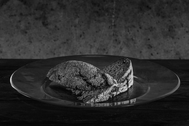 两块小面包放在一个大玻璃板上，靠在一面粗糙肮脏的墙上图片下载